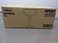 Box packaging for the set of 12 Libbey SPKSY champagne flutes showing brand, model number 601602, quantity, and capacity.