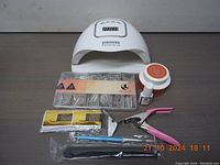 Full kit including UV lamp, nail tips, gels, and manicure tools all displayed on table