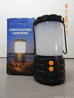 Side view of the LED camping lantern showing the box labeled 'LED CAMPING LANTERN' and the lantern itself placed beside it.