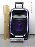 Front view of ION Total Freedom PA speaker with illuminated edge-glow lights and cardboard box to the left.