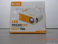 Front view of KHQ LED mini portable projector VF260 in packaging showing model and branding