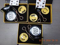 Three black rectangular boxes each containing two pairs of magnetic eyelashes and a rose gold eyelash applicator.