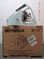 Teal BETTERSJB Tumbler Heat Press Machine sitting on its original cardboard box with visible branding and instructions.
