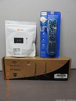 Philips remote control in original packaging, professional bias lighting in sealed white package, and the TV stand box labeled PCOLLECOTH