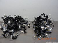 Two long strands of outdoor LED Edison bulb style string lights coiled on the floor showing multiple clear bulbs and black wiring.