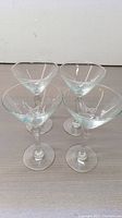 Four clear glass martini glasses viewed from above showing bowl shape and size.