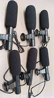 Set of six wired Digi Power microphones with black foam windscreens and mounting clips laid out on a flat surface.