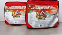 Two Emergency Roadside Safety Kits in clear and red cases, showing front label with contents list.