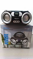 Megatek portable CD player on top of original box showing front view with speakers and display.