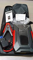 Complete kit including jump starter, jumper cables, power adapter, user manual, and carry case.
