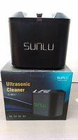 Black Sunlu Ultrasonic Cleaner unit displayed on top of its retail box showing front with logo.