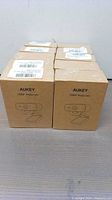 Multiple Aukey branded webcam boxes stacked in two rows showing quantity and packaging.