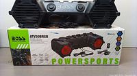 Boss Audio System ATV30BRGB portable outdoor sound system displayed on its original box showing speaker grills, controls, and wired attachments.