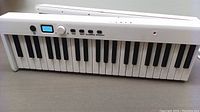 Front view showing 61 white and black keys with LCD display, rotary knob and function buttons
