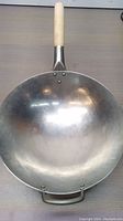 Top view of the carbon steel wok showing the flat bottom and wooden handle.
