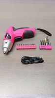 Pink Hi-Spec electric screwdriver with sets of bits and USB charger laid out on table