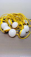 Full set of 10 spherical LED bulbs attached to a lengthy yellow industrial cable.