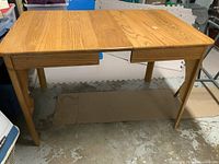 Top view of solid oak rectangular dining table with natural finish showing the wood grain and leaf extension seating surface.
