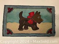 Front view of the hand hooked rug showing brown dog with red bow, framed by blue and red floral corners.