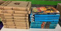 Stack of eight vintage hardcover Hardy Boys books by F.W. Dixon with brown cloth binding and black text on spine.