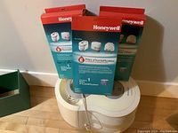 White Honeywell HCM-6000 humidifier with three replacement filter boxes placed on top