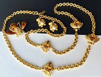 Full view of the gold-tone Joan Rivers necklace with large chain and multiple bumble bee charms, the bumble bee brooch, and the bear earrings all displayed on a white background