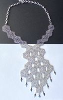 Full view of the vintage silver-tone filigree snowflake necklace laid flat showing overall design and length.
