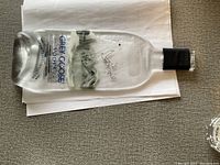 Flattened Grey Goose Vodka glass bottle ashtray, shown from the front side with label and logo visible.