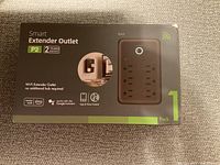 Boxed smart extender outlet power strip showing packaging with product features and compatibility icons printed on front.