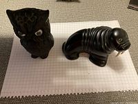Both figurines on graph paper showing size and details