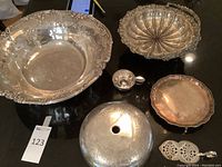 Overview of full set showing two bowls, dome lid, small cup, tray and cake slice utensil arranged on black surface