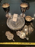 Photo of the goblets, sectioned glass dish, small handled dish, and two cake servers with a ruler for scale