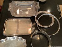 Overview photo showing all trays including rectangular trays and round pieces, with reflective surfaces and some patina