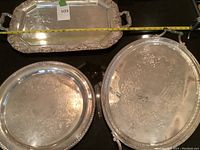 All three silver plate trays arranged on a table with a measuring tape showing length of large rectangular tray.