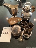 Overview showing two boats, lidded pitcher, vanity jar and napkin rings