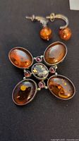 Amber and stone brooch with four large oval amber resin stones and central smoky and red/purple accent stones