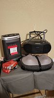 Full view of the lot items together: space heater, boombox, head massager, cassette tapes