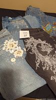 Four pairs of Diane Gilman embellished jeans in sizes 4-6P showing floral and scrollwork embroidery and rhinestones
