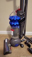 Close-up of Dyson DC50 vacuum base with motorized brush and dust container under handle.