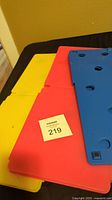 Three colored folding boards stacked: yellow, red, and blue on top, shown flat.