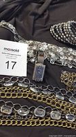 Jewelry lot with Joan Rivers rectangular silver-tone watch, 44-inch RJ Graziano multi-strand necklace with mixed chain links and faceted stones, and part of hematite look spring bracelet.