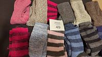 Photo showing 12 pairs of assorted ladies wool socks in various colors and stripes, arranged side-by-side on a flat surface