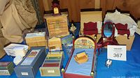 Wide view of miniature furniture including Noah's Ark-themed bed, wooden ark boat, bathroom suite pieces like bathtub and cabinets, and boxed items.