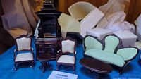 Miniature Victorian furniture set displayed including sideboard, chairs, accent table, sofa, and sofa table with light green upholstery and dark wood