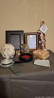 Overview of all miscellaneous decor items including piggy bank, ammonite, marble coasters, magnetic strip, magnifying glass, and picture frames on display.
