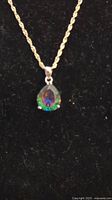 Front view of the necklace showing the twisted rope chain and teardrop mystic topaz pendant with aurora borealis colors.