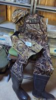 Full view of the neoprene waders with hat and vest laid out on a chair.