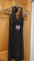 Chocolate brown sparkly halter dress hanging on hanger, showing full length and halter neck tie