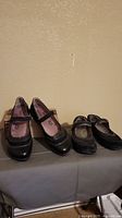 Front view of both pairs of shoes showing the Taos Mary Janes on the left and Aerosoles slip-on shoes on the right.