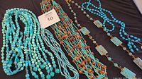Overall view of four turquoise look necklaces laid out to display different styles and bead types.